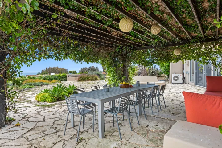 Espace repas sous une pergola végétalisée
